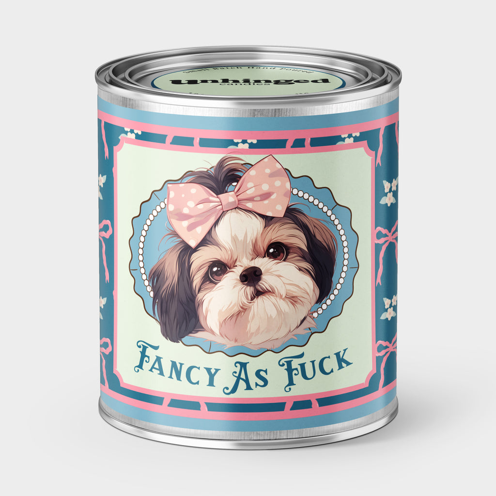 An Unhinged Paintcan candle with a picture of a cute puppy with a bow with the phrase "Fancy as fuck" on a blue and pink background. 
