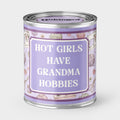 An Unhinged candle Paintcan vessel with the label "Hot girls have grandma hobbies" with a sewing and knitting background. 