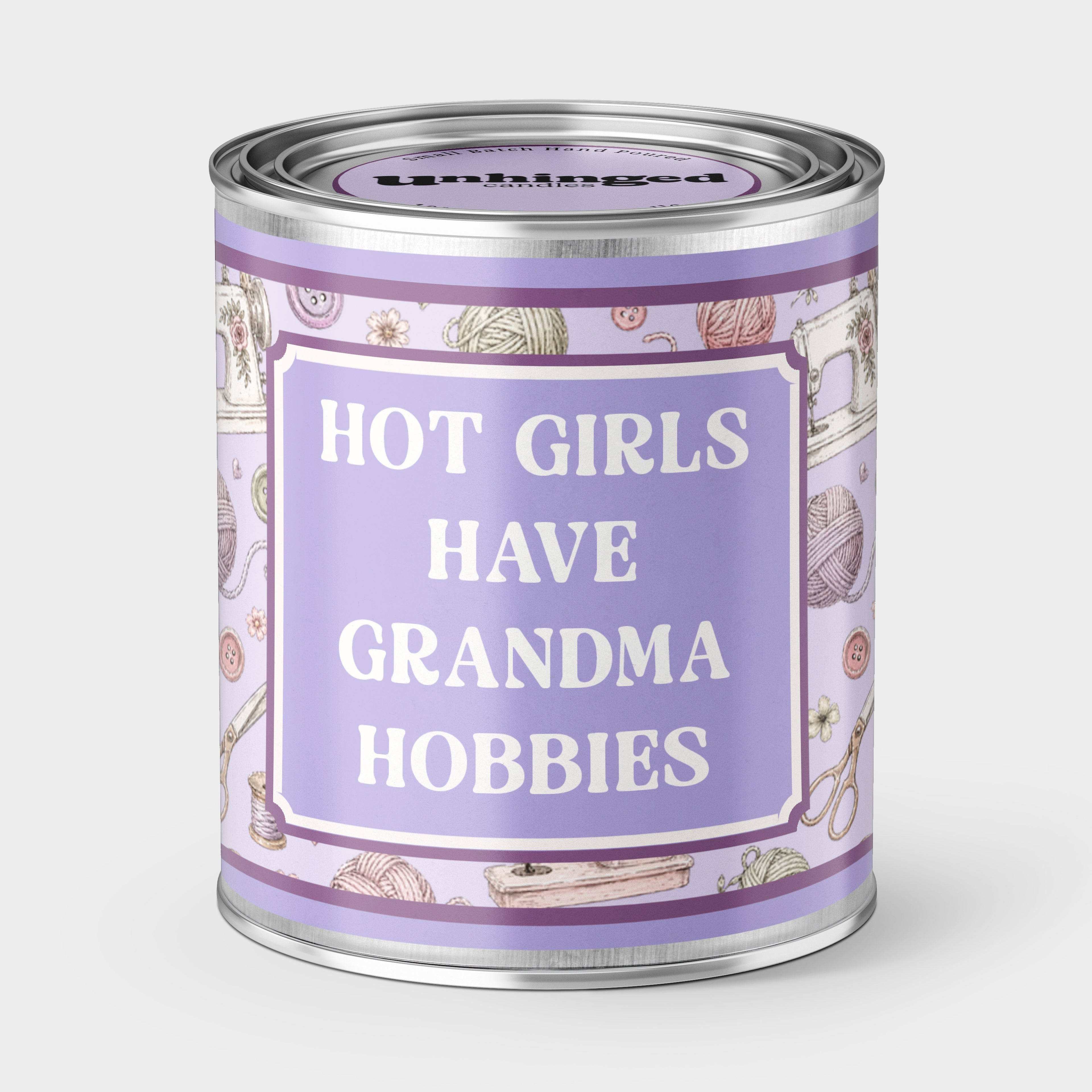 An Unhinged candle Paintcan vessel with the label "Hot girls have grandma hobbies" with a sewing and knitting background. 