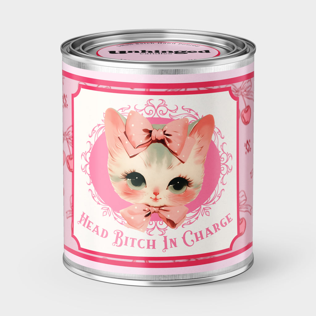 An Unhinged Candle Paintcan vessel with a label stating "Head bitch in charge" with a vintage illustration of a cute Kitten with pink and white striped background.